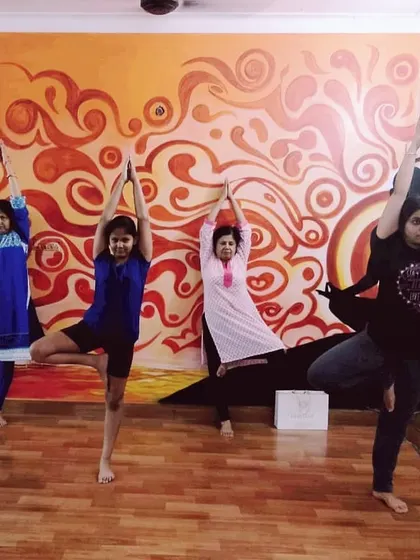 Students of different ages practicing Vrikshasana (Tree Pose) together in our Noida studio. This asana is excellent for improving balance and grounding your energy.
