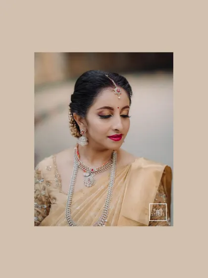 A close-up portrait of the bride in a beautiful golden saree. Her serene expression and traditional jewelry are the highlights of this classic shot.