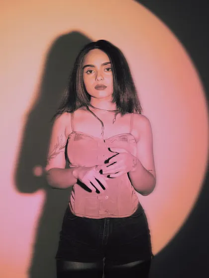 A portrait in a pink spotlight. This was to promote a closing set where I promised to take the crowd to a "dark grey cloud in the sky" with acid, punk, and bass-heavy grooves.