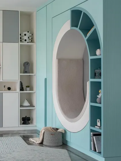 For this child's bedroom, we designed a world of imagination. The centerpiece is this cozy, circular reading nook built into the wall, surrounded by integrated shelving for books and treasures. It’s a functional and playful sanctuary for a child to read, dream, and grow.