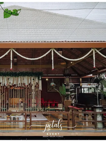 The interior of a traditional venue, decorated with tuberose and chrysanthemum garlands and temple bells.