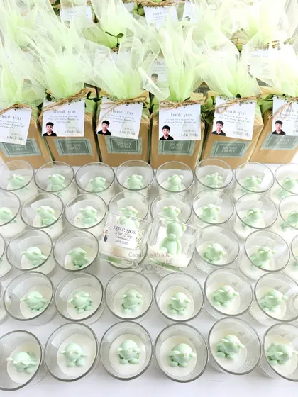 The fully assembled return gifts for John's Holy Communion, with the teddy bear candles boxed, net-wrapped, and tagged with personalized cards.