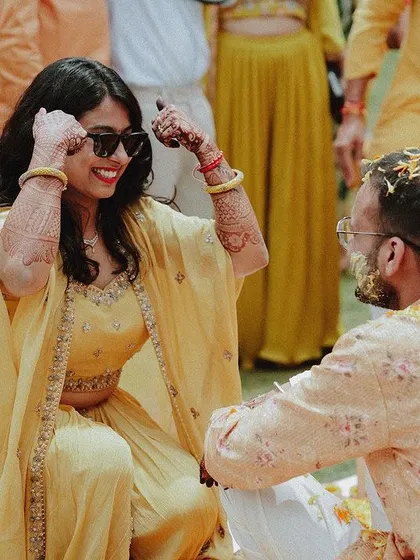 A duplicate of the bride and groom's playful interaction during the Haldi application.