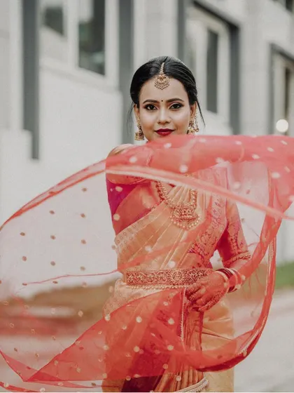 A radiant look for this beautiful bride. The makeup is kept fresh and glowing, paired with a sleek saree drape and a lovely floral braid.