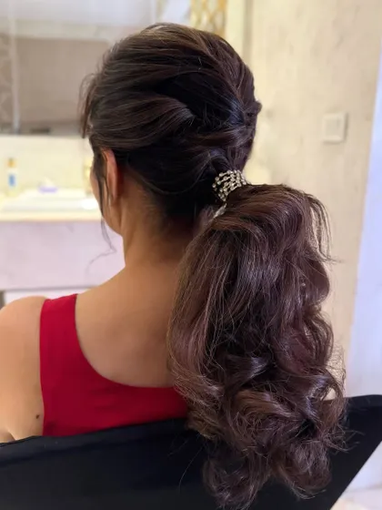 A textured, twisted low ponytail with a crystal accessory, a romantic and stylish option.