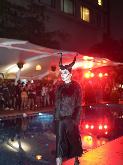 A model in a Maleficent-inspired costume walks the poolside runway. The fashion show was a highlight of the night.