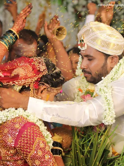 A powerful close-up of the groom tying the mangalsutra, surrounded by the energy of family and friends. We focus on the central action while preserving the atmosphere of the moment.