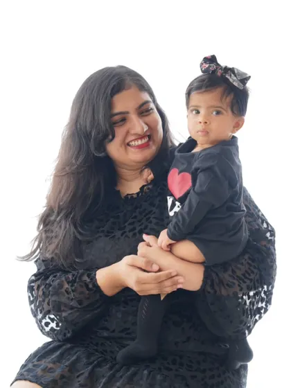 A mother holds her daughter, who is looking curiously at the camera. A beautiful, candid moment.
