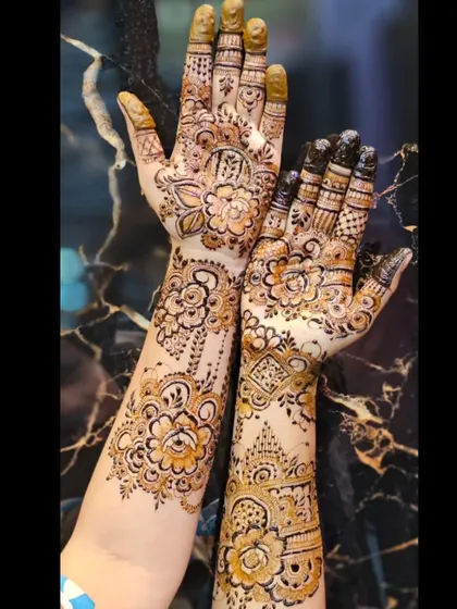 A lovely designer mehendi combining floral patterns on one hand with more geometric and traditional motifs on the other.