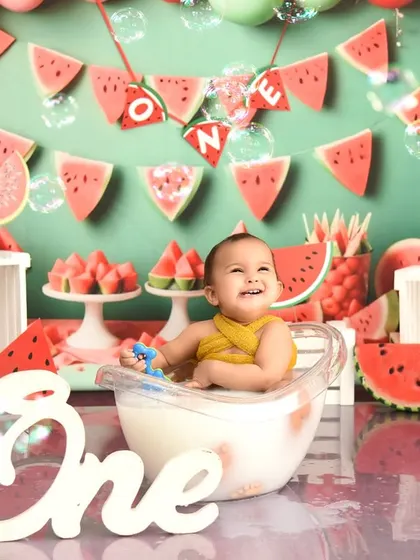 A post-cake smash splash in a tub is the perfect way to end a watermelon-themed first birthday shoot. It's all about capturing pure, unscripted fun.