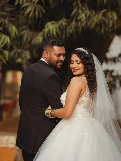A classic bridal portrait. Janice looks back with a smile, her curly hair perfectly coiffed to complement her stunning gown.
