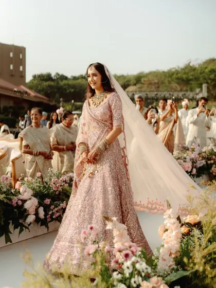 The bride's walk down the aisle, surrounded by a garden of pastel blooms. The decor was designed to make her entrance feel like a scene from a fairytale.