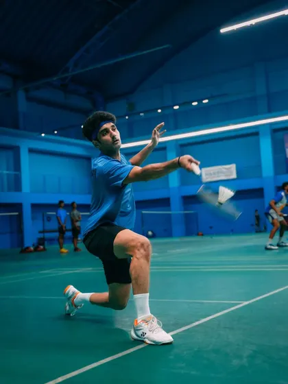Focus and form in action. A player prepares to return a shot with perfect kneeling posture, a testament to the detailed coaching provided at our academy.