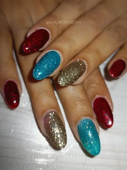 A bold and festive set for New Year's celebrations, featuring a mix of glittery red, blue, and gold nails.