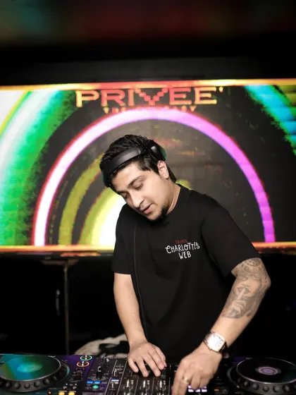 A close-up shot of me working the decks at Priveé. The colorful visuals in the background are a key part of the immersive experience we create for the audience every night.