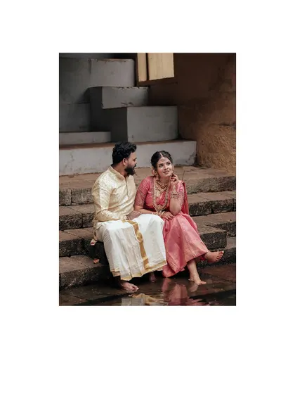 A sweet moment of a couple sitting on temple steps, dipping their feet in the water.