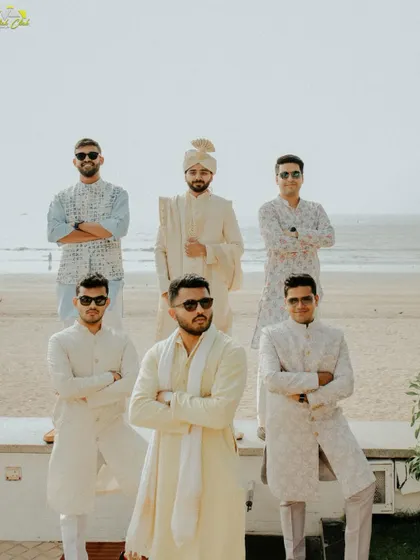 The groom and his groomsmen looking sharp by the beach. This is a cool, stylish group portrait that captures the camaraderie and anticipation before the wedding ceremony.