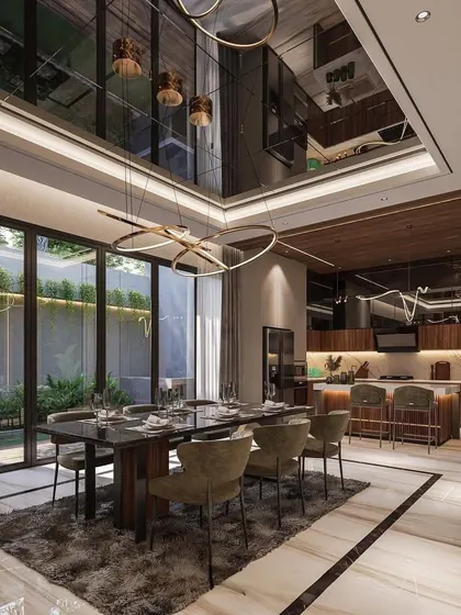 A luxurious open-plan living and dining area with the kitchen visible in the background. The design shows how we create a cohesive look across different functional zones using complementary materials and lighting.