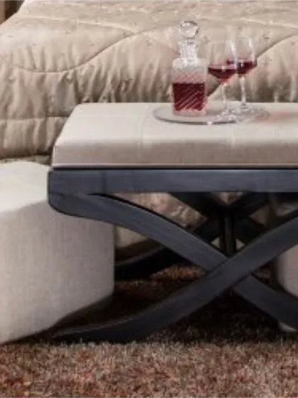 The bench with its matching ottomans tucked underneath. This demonstrates the space-saving aspect of the design, providing flexible seating options that can be neatly stored away when not in use.