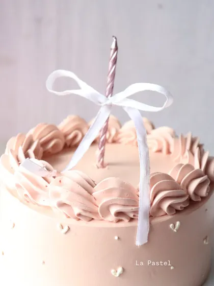 A close-up of the piping and the tiny white hearts on this sweet and simple cake.