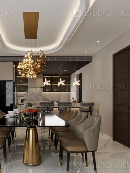A dining area in Krishna Park, New Delhi, featuring a dramatic chandelier and an open-plan layout that connects to a modern kitchen with a breakfast bar.