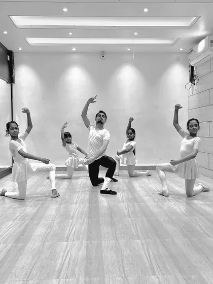 A group of young ballerinas in a synchronized pose with me during a class. These photos show the discipline and coordination we build in our ballet program.