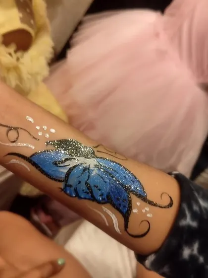 A sparkling blue butterfly arm painting design, another great option for party entertainment.