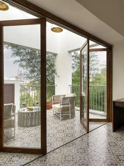 The sliding folding glass doors in the 'A Walk in the Clouds' home office flood the space with natural light and provide a seamless connection to the balcony and the bamboo garden outside.