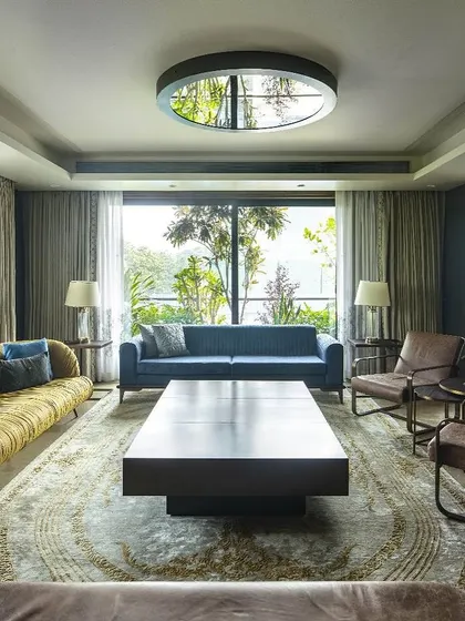 The living room of the Barkat residence is designed as a glass pavilion, with floor-to-ceiling windows on multiple sides that immerse the inhabitants in nature. A circular skylight further enhances the connection to the sky and daylight.