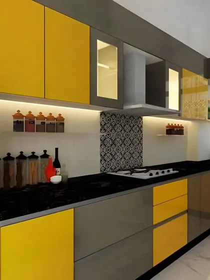 A bold and modern kitchen featuring a combination of grey and yellow cabinets. The design includes a black countertop and a patterned backsplash, creating a high-contrast and energetic space.
