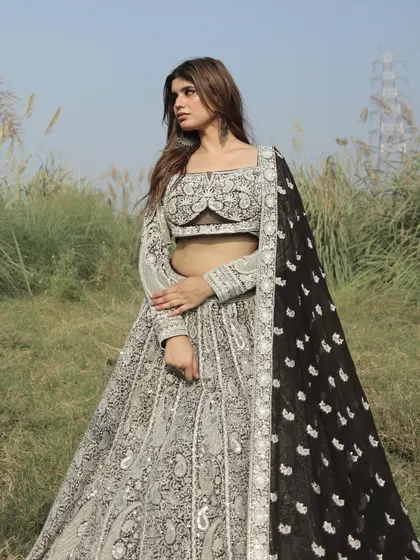 This black and white embroidered lehenga is a masterpiece of contrast. The traditional paisley motifs are given a modern update in this striking color combination.