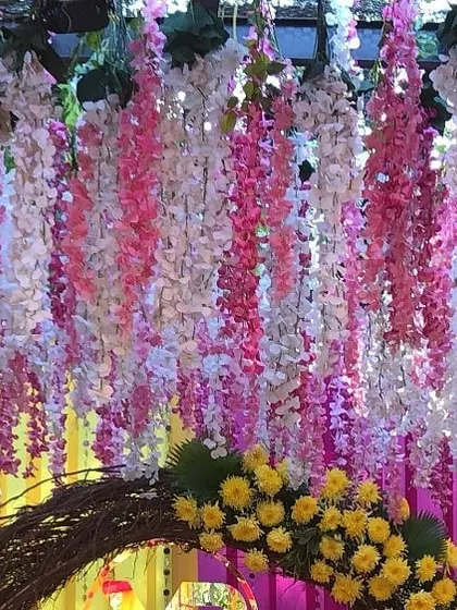 Another angle of the hanging floral decor, showing how it combines with a rustic twig arch and bright yellow flowers. It's these details that bring a design to life.