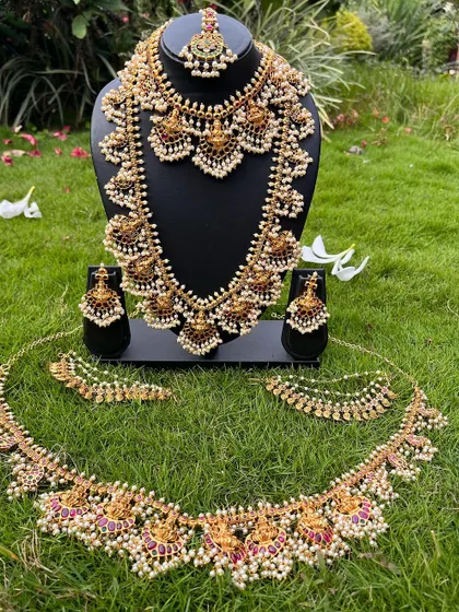 A full South Indian bridal set with temple and pearl work. This rental includes a choker, haaram, vaddanam, bajuband, and jhumkas for a complete head-to-toe look.