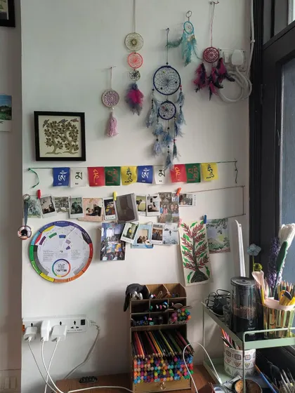 A corner of my studio, filled with dreamcatchers, prayer flags, and photos. This is my safe haven, a space that inspires me.
