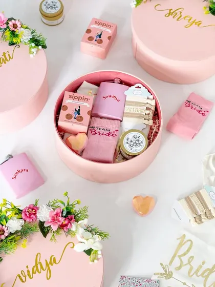 A complete "Team Bride" set. This includes personalized round boxes, hip flasks, tote bags, and socks. We can create a whole theme for your bridal party.