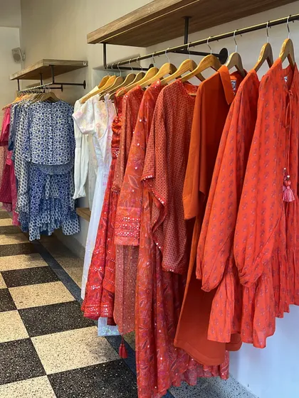 A rack of vibrant red and blue block-printed outfits at a boutique in Jaipur. I love finding stores that offer both festive and inexpensive options for my clients.