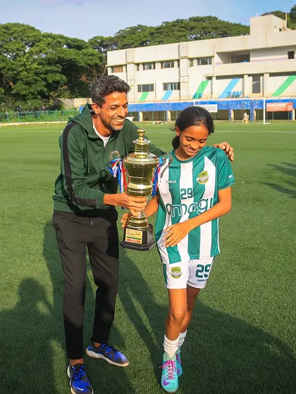 A proud moment between coach and player. Our coach presents the championship trophy to a U13 player, highlighting the mentorship that is key to our program.