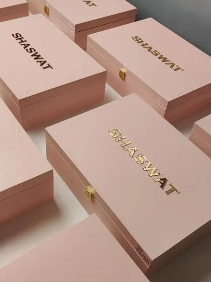 The finished look of the custom pink boxes for the Shaswat store opening, featuring the brand name in a classy gold acrylic finish. The packaging is just as important as the gift itself.