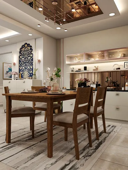This dining room showcases a beautiful blend of modern and traditional elements, with a mirrored crockery unit and a stunning blue Pichwai-style wall art.