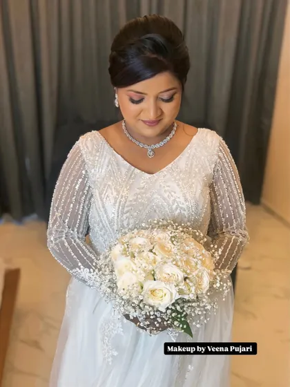 A close-up of the bride's makeup. The look features soft, shimmery eyeshadow, a natural lip color, and a flawless base, creating a classic and romantic bridal style.