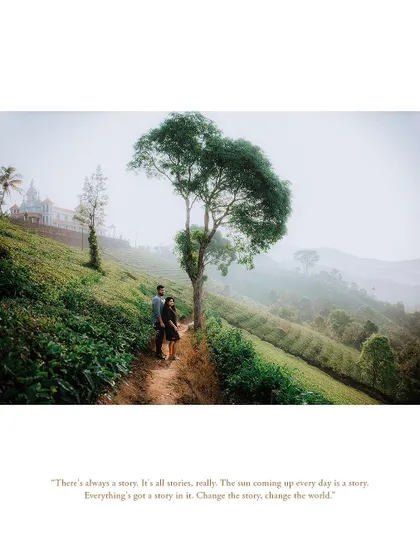 A wide shot of a couple in a tea plantation, with a beautiful building in the background, capturing the scale of the landscape.