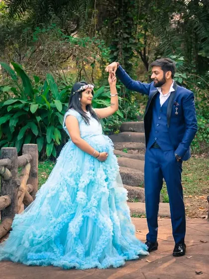 A fairytale moment on a bridge. The expecting mother in a stunning light blue ruffled gown looks like a princess, creating a truly magical and memorable maternity portrait.
