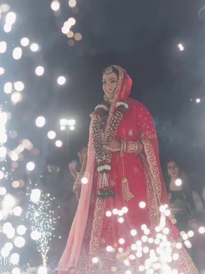 A magical shot of Bhavika surrounded by sparklers. Her makeup glows beautifully, creating a truly cinematic and unforgettable bridal moment.