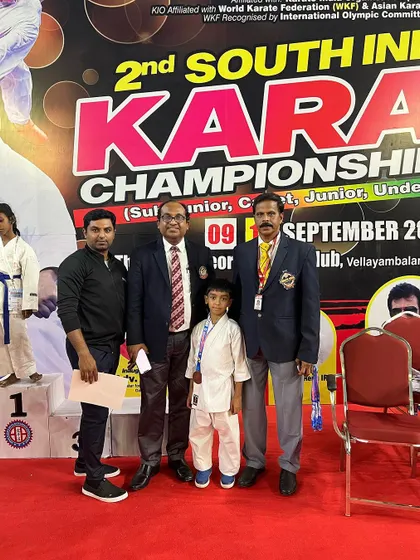Posing with my son and officials, a moment of pride for our academy at the South India Karate Championship.