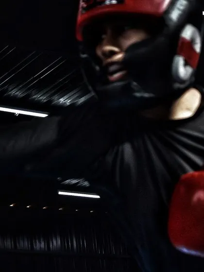 A female boxer throwing a straight right hand during a sparring session. Notice the focus and form, even in the heat of the moment.