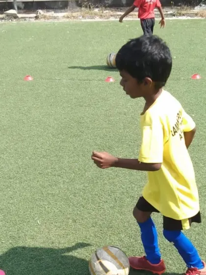 A grassroots player in our yellow training kit, learning the basics of ball control.