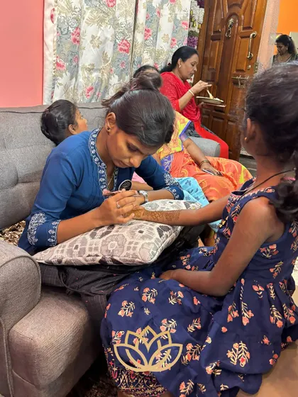 A member of my team carefully applying mehendi to a young guest. We are patient and gentle with clients of all ages.