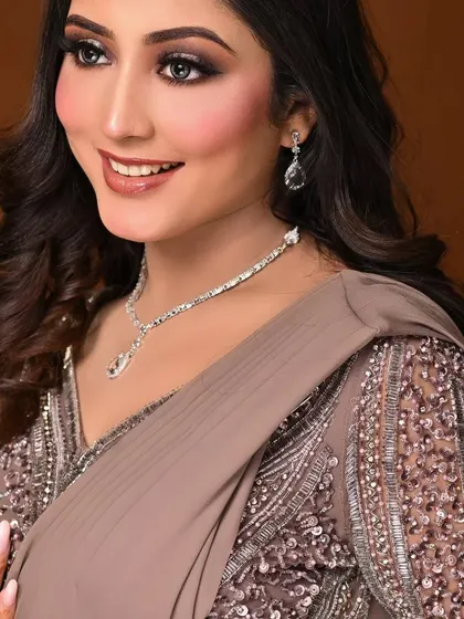 This smiling shot shows how a glam look can still feel light and celebratory. The glowing skin and glossy lips are key.