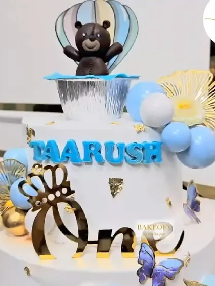 Celebrating little Taarush’s first birthday with this dreamy 3.5kg Choco Vanilla hot air balloon themed cake. It's decorated with a cute bear, butterflies, and golden accents.