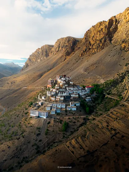 A classic view of the Key Monastery, showcasing its unique placement on the hillside. The morning light beautifully illuminates the white-washed walls of this ancient Buddhist gompa.